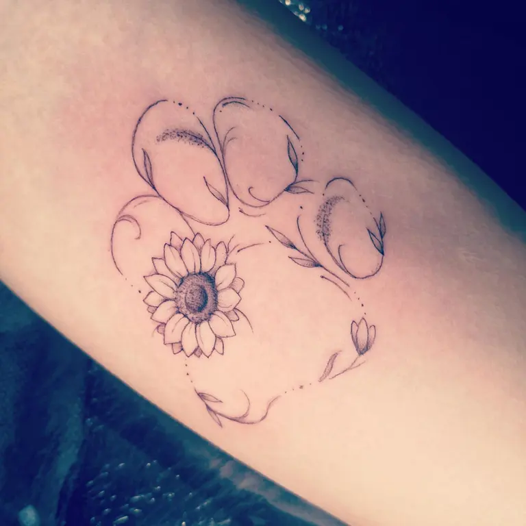 Profilo di cane con piccolo fiore tatuato su un arto.