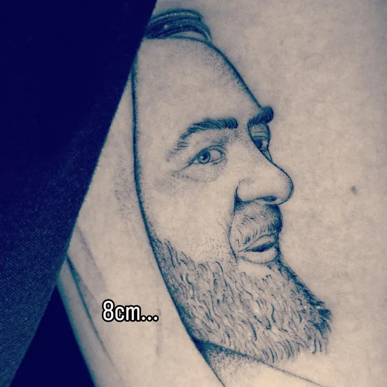 Ritratto tatuato di Padre Pio su un arto.