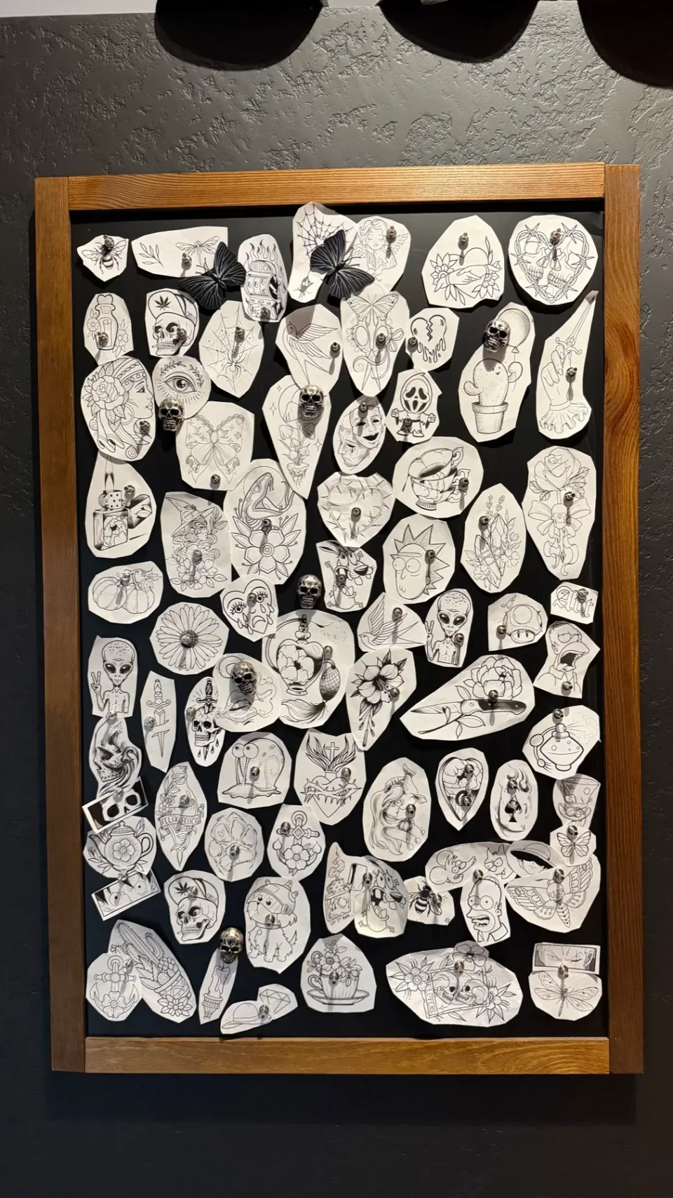 Cornice con una raccolta di disegni tattoo nello studio.