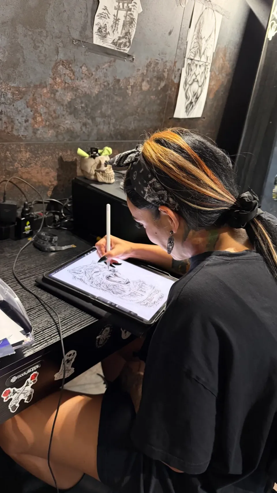 Jamila mentre disegna sul tablet alla sua postazione.